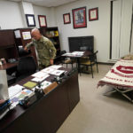 
              Capt. Michael Switzer goes to sit at his desk before he goes to sleep in his office at Camp Beauregard in Pineville, La., Friday, July 30, 2021. (AP Photo/Gerald Herbert)
            