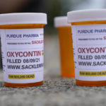 
              FILE - In this Aug. 9, 2021, file photo, fake pill bottles with messages about OxyContin maker Purdue Pharma are displayed during a protest outside the courthouse where the bankruptcy of the company is taking place in White Plains, N.Y. A federal bankruptcy judge is expected to rule Wednesday, Sept. 1, on whether to accept a settlement between Purdue Pharma, the states and thousands of local governments over an opioid crisis that has killed a half-million Americans over the last two decades. (AP Photo/Seth Wenig, File)
            