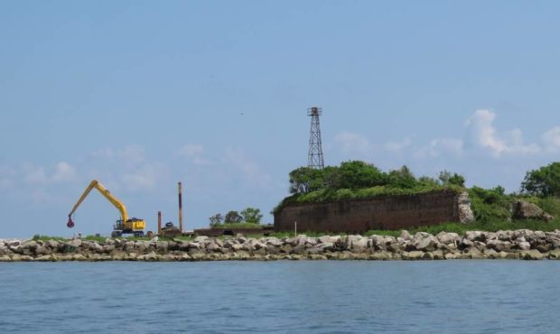 An excavator moves rocks weighing 5,000 to 12,000 pounds from a barge to protect a Louisiana barrie...