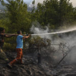 
              Villagers water trees to stop the wildfires that continue to rage the forests in Manavgat, Antalya, Turkey, early Sunday, Aug. 1, 2021. The fires in Antalya were continuing overnight in Manavgat and Gundogmus districts. In Bodrum, Mugla, they continued to burn down forests, encroaching on villages and tourist destinations and forcing people to evacuate by boats. (AP Photo)
            