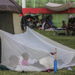 
              A family wakes inside a mosquito net outside a tent after spending the night at a soccer field following Saturday´s 7.2 magnitude earthquake in Les Cayes, Haiti, Sunday, Aug. 15, 2021. (AP Photo/Joseph Odelyn)
            