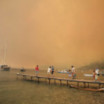 
              Tourists wait to be evacuated from the smoke-engulfed Mazi area as wildfires rolled down the hill toward the seashore, in Bodrum, Mugla, Turkey, Sunday, Aug. 1, 2021. More than 100 wildfires have been brought under control in Turkey, according to officials. The forestry minister tweeted that five fires are continuing in the tourist destinations of Antalya and Mugla. (AP Photo/Emre Tazegul)
            