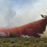 
              FILE — In this July 5, 2017 file photo an air tanker drops retardant near homes to protect them from a wildfire in the Palomino Valley, near Reno, Nev. The Center for Biological Diversity filed a lawsuit, under the Freedom of Information Act in Reno this week, Friday, Aug. 13, 2021,  against the U.S Bureau of Land Management accusing federal land managers of illegally withholding information about environmental assessments used to justify plans to create fuel breaks to slow wildfires by clearing forests and shrubs across rangeland six western states.(Jason Bean/The Reno Gazette-Journal via AP)
            