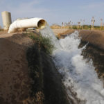 
              Water flows into a canal that feeds farms run by Tempe Farming Co., in Casa Grande, Ariz., Thursday, July 22, 2021. The Colorado River has been a go-to source of water for cities, tribes and farmers in the U.S. West for decades. But climate change, drought and increased demand are taking a toll. The U.S. Bureau of Reclamation is expected to declare the first-ever mandatory cuts from the river for 2022. (AP Photo/Darryl Webb)
            