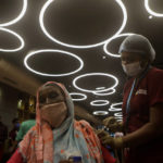 
              A health worker inoculates a woman against COVID-19 at vaccination center set up inside a shopping mall that remains closed to business in Mumbai, India, Wednesday, Aug. 11, 2021. (AP Photo/Rajanish Kakade)
            