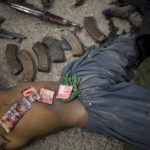 
              Pakistani bank notes covered in blood are displayed on the body of a dead suicide bomber after police found them in his pocket in the center of Kandahar, Afghanistan, Wednesday, March 12, 2014, after an attack on the former Afghan intelligence headquarters. Police officials said three insurgents who tried to storm the former headquarters of Afghanistan's intelligence service in southern Kandahar died in a gunbattle with security forces. (AP Photo/Anja Niedringhaus)
            