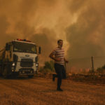 
              A man runs, in the fire-devastating Sirtkoy village, near Manavgat, Antalya, Turkey, Sunday, Aug. 1, 2021. More than 100 wildfires have been brought under control in Turkey, according to officials. The forestry minister tweeted that five fires are continuing in the tourist destinations of Antalya and Mugla. (AP Photo)
            