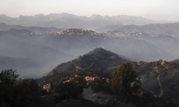 In this photo taken Wednesday, Aug.11, 2021, smoke invites the mountains after wildfires in the vil...