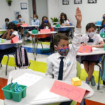 
              Student Winston Wallace, 9, raises his hand in class at iPrep Academy on the first day of school, Monday, Aug. 23, 2021, in Miami. Schools in Miami-Dade County opened Monday with a strict mask mandate to guard against coronavirus infections. (AP Photo/Lynne Sladky)
            