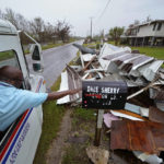 
              Derrick Campbell, postmaster for Montegut, La., delivers mail amidst destruction from Hurricane Ida, in Pointe-aux-Chenes, La., Tuesday, Sept. 14, 2021. (AP Photo/Gerald Herbert)
            