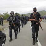 
              Kosovo police officers walk to replace their colleagues near the northern Kosovo border crossing of Jarinje on Tuesday, Sept. 21, 2021. Tensions soared Monday when Kosovo special police with armored vehicles were sent to the border to impose a rule on temporarily replacing Serb license plates from cars while they drive in Kosovo. (AP Photo/Visar Kryeziu)
            