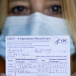 
              In this Monday, Sept. 27, 2021, photo Bronwyn Russell holds her COVID-19 vaccination record card as she poses for a photo at her home in Des Plaines, Ill. Russell wears a mask anytime she leaves her Illinois home. “I’m worried. I don’t want to get sick,” says Russell. (AP Photo/Nam Y. Huh)
            