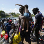 
              Haitian migrants use a dam to cross into and from the United States from Mexico, Saturday, Sept. 18, 2021, in Del Rio, Texas. The U.S. plans to speed up its efforts to expel Haitian migrants on flights to their Caribbean homeland, officials said Saturday as agents poured into a Texas border city where thousands of Haitians have gathered after suddenly crossing into the U.S. from Mexico. (AP Photo/Eric Gay)
            
