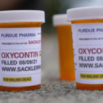 In this file photo, fake pill bottles with messages about OxyContin maker Purdue Pharma are displayed during a protest outside the courthouse where the bankruptcy of the company is taking place in White Plains, N.Y. (AP Photo/Seth Wenig, File)