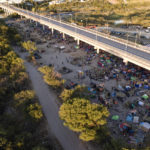 
              Migrants, many from Haiti, are seen in an encampment along the Del Rio International Bridge near the Rio Grande, Thursday, Sept. 23, 2021, in Del Rio, Texas. (AP Photo/Julio Cortez)
            