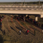 
              Migrants, many from Haiti, are seen in lines waiting to board busses at an encampment along the Del Rio International Bridge near the Rio Grande, Thursday, Sept. 23, 2021, in Del Rio, Texas. (AP Photo/Julio Cortez)
            