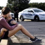 
              Carly McWatters holds her son at Collierville Town Hall on Friday, Sept. 24, 2021, in Collierville, Tenn., to pay their respects to the victims of the Kroger shooting the day before. (Patrick Lantrip/Daily Memphian via AP)
            