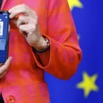 
              FILE - In this June 16, 2021, file photo, European Commission President Ursula von der Leyen shows a phone, as she gives a press statement on the new COVID-19 digital travel certificate at the European Commission headquarters in Brussels. In both the U.S. and the EU, officials are struggling with the same question: how to boost vaccination rates to the max and end a pandemic that has repeatedly thwarted efforts to control it. In the European Union, officials in many places are requiring people to show proof of vaccination, a negative test or recent recovery from COVID-19 to participate in everyday activities — even sometimes to go to work. (Johanna Geron/Pool Photo via AP, File)
            