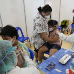 
              A mother tries to comfort her child before receiving the Pfizer-BioNTech COVID-19 vaccine at a hospital in Bangkok, Thailand, Tuesday, Sept. 21, 2021. Bangkok Metropolitan Administration started inoculated 12-18 year old students Tuesday as part of its attempt to reopen on-site schools. (AP Photo/Sakchai Lalit)
            