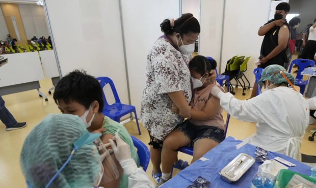 A mother tries to comfort her child before receiving the Pfizer-BioNTech COVID-19 vaccine at a hosp...