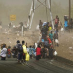 
              A dust storm moves across the area as Haitian migrants use a dam to cross into the United States from Mexico, Saturday, Sept. 18, 2021, in Del Rio, Texas. U.S. officials said that within the next three days, they plan to ramp up expulsion flights for some of the thousands of Haitian migrants who have gathered in the Texas city from across the border in Mexico. (AP Photo/Eric Gay)
            