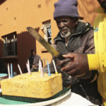 
              A 103 year old man is helped to cut a banana bread cake during his birthday celebrations at Melfort Old People's home on the outskirts of Harare, Zimbabwe, Sunday, July 25, 2021. The economic ravages of COVID-19 are forcing some families in Zimbabwe to abandon the age old tradition of taking care of the elderly. Zimbabwe's care homes have experienced a 60% increase in admissions since the outbreak of the pandemic in March last year. (AP Photo/Tsvangirayi Mukwazhi)
            
