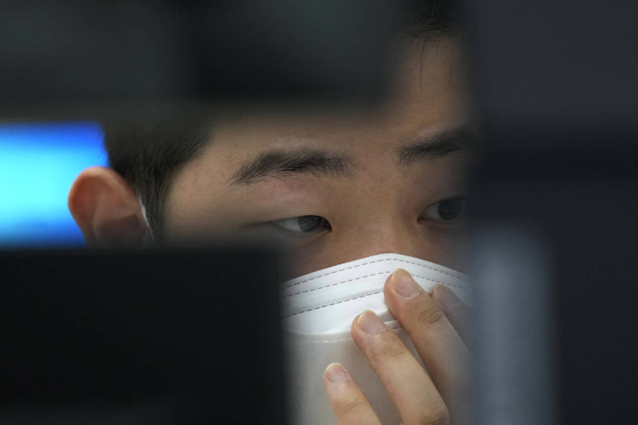 A currency trader watches monitors at the foreign exchange dealing room of the KEB Hana Bank headqu...