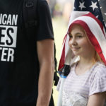 
              A your girl wears a flag over her head during a rally near the U.S. Capitol in Washington, Saturday, Sept. 18, 2021. The rally was planned by allies of former President Donald Trump and aimed at supporting the so-called "political prisoners" of the Jan. 6 insurrection at the U.S. Capitol. (AP Photo/Alex Brandon)
            