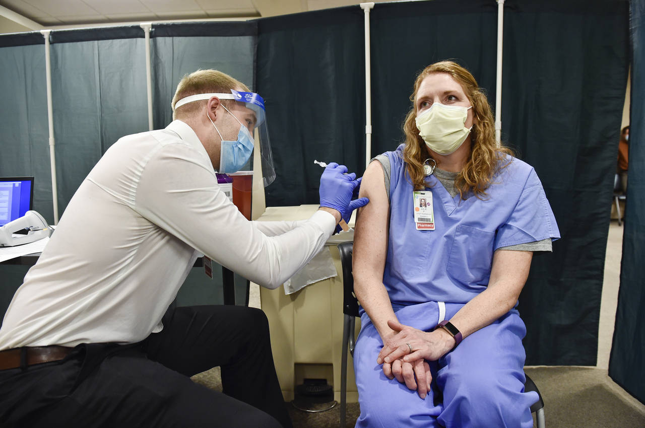 FILE - In this Dec. 16, 2020, file photo, Julie Petre, an ICU pharmacist, receives the Pfizer-BioNT...