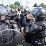 
              Police circle a man, center with glasses, during a rally near the U.S. Capitol in Washington, Saturday, Sept. 18, 2021. The rally was planned by allies of former President Donald Trump and aimed at supporting the so-called "political prisoners" of the Jan. 6 insurrection at the U.S. Capitol. (AP Photo/Gemunu Amarasinghe)
            