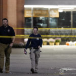 
              Law enforcement personnel walk in front of a Kroger grocery store as an investigation goes into the night following a shooting earlier in the day on Thursday, Sept. 23, 2021, in Collierville, Tenn. Police say a gunman attacked people in the store and killed at least one person and wounded 12 others before the suspect was found dead. (AP Photo/Mark Humphrey)
            