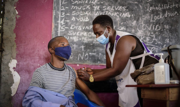 A nurse administers a coronavirus vaccination at Kisenyi Health Center in downtown Kampala, Uganda ...