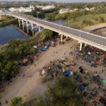 
              Migrants, many from Haiti, are seen at an encampment along the Del Rio International Bridge near the Rio Grande, Tuesday, Sept. 21, 2021, in Del Rio, Texas.  The options remaining for thousands of Haitian migrants straddling the Mexico-Texas border are narrowing as the United States government ramps up to an expected six expulsion flights to Haiti and Mexico began busing some away from the border.  (AP Photo/Julio Cortez)
            