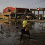 
              A man goes for gas at a hurricane-damaged gas station in the aftermath of Ida, Monday, Sept. 6, 2021, in Grand Isle, La. (AP Photo/John Locher)
            