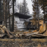
              FILE - In this Sept. 2, 2021 file photo a cabin partially covered in fire-resistant material stands behind a property destroyed in the Caldor Fire in Twin Bridges, Calif.  Aluminum wraps designed to protect homes from flames are getting attention as wildfires burn in California. During a fire near Lake Tahoe, some wrapped houses survived while nearby homes were destroyed. The material resembles tin foil from the kitchen drawer but is modeled after the tent-like shelters that wildland firefighters use as a last resort to protect themselves when trapped by flames.  (AP Photo/Jae C. Hong,File)
            