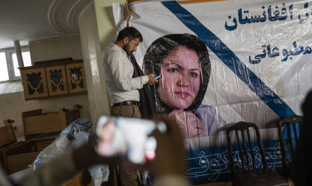 A man holds a poster of Afghan politician Fawzia Koofi prior to a press conference organized by the...