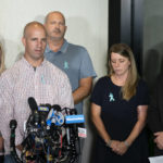 
              Jim Schmidt, center left, stepfather of Gabby Petito, whose death on a cross-country trip has sparked a manhunt for her boyfriend Brian Laundrie, speaks alongside Joseph Petito, father, center, Nichole Schmidt, mother, center right, Tara Petito, stepmother, left, and the family attorney Richard Stafford, right, during a news conference, Tuesday, Sept. 28, 2021, in Bohemia, N.Y. (AP Photo/John Minchillo)
            