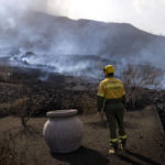 
              A municipal worker looks as smoke rises after a volcano erupted, near El Paso on the island of La Palma in the Canaries, Spain, Tuesday, Sept. 21, 2021. A dormant volcano on a small Spanish island in the Atlantic Ocean erupted on Sunday, forcing the evacuation of thousands of people. Huge plumes of black-and-white smoke shot out from a volcanic ridge where scientists had been monitoring the accumulation of molten lava below the surface. (AP Photo/Emilio Morenatti)
            