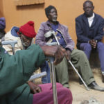 
              Elderly men wait to be served a meal at Melfort Old People's home on the outskirts of Harare, Zimbabwe, Sunday, July 25, 2021. The economic ravages of COVID-19 are forcing some families in Zimbabwe to abandon the age old tradition of taking care of the elderly. Zimbabwe's care homes have experienced a 60% increase in admissions since the outbreak of the pandemic in March last year. (AP Photo/Tsvangirayi Mukwazhi)
            
