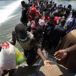 
              Haitian migrants use a dam to cross into and from the United States from Mexico, Saturday, Sept. 18, 2021, in Del Rio, Texas. The U.S. plans to speed up its efforts to expel Haitian migrants on flights to their Caribbean homeland, officials said Saturday as agents poured into a Texas border city where thousands of Haitians have gathered after suddenly crossing into the U.S. from Mexico. (AP Photo/Eric Gay)
            