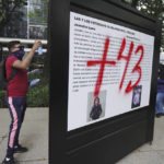 
              A demonstrator protesting the disappearance of 43 university students sprays graffiti on a display during a march on the seventh anniversary of their disappearance, in Mexico City, Sunday, Sept. 26, 2021. Relatives continue to demand justice for the Ayotzinapa students who were allegedly taken from the buses by the local police and handed over to a gang of drug traffickers. (AP Photo/Marco Ugarte)
            