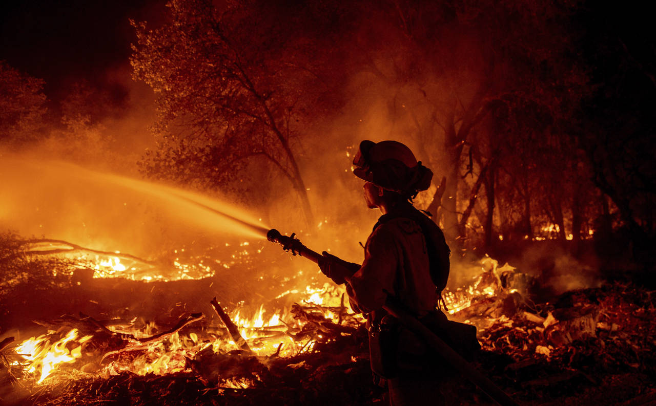 Firefighter Ron Burias battles the Fawn Fire as it spreads north of Redding, Calif. in Shasta Count...