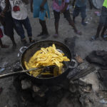 
              A vendor fries a batch of plantains at a market in the La Saline neighborhood near the main port entrance, partially burned by a gang two years ago, in Port-au-Prince, Haiti, Monday, Sept. 13, 2021. There could be as many as 100 gangs in Port-au-Prince; no one has an exact count and allegiances often are violently fluid. (AP Photo/Rodrigo Abd)
            
