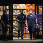 
              Responders walk out the door of a Kroger grocery store as the investigation goes into the night following a shooting earlier in the day, Thursday, Sept. 23, 2021, in Collierville, Tenn. (AP Photo/Mark Humphrey)
            