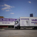 
              An instructor drives whilst training a learner truck driver sat next to him in the truck cab, at the National Driving Centre in Croydon, south London, Wednesday, Sept. 22, 2021. Britain doesn't have enough truck drivers. The shortage is contributing to scarcity of everything from McDonald's milkshakes to supermarket produce. (AP Photo/Matt Dunham)
            