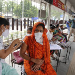 
              A health worker administers the vaccine for COVID-19 during a special vaccination drive by the municipal corporation at a bus stand in Ahmedabad, India, Friday, Sept. 17, 2021. (AP Photo/Ajit Solanki)
            