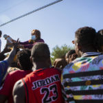 
              Araselli Zamora from San Antonio hands resources including food, clothing and baby carriers to a group of migrants early Friday, Sept. 17, 2021, in Ciudad Acuña, Mexico. Haitians crossed the Rio Grande freely and in a steady stream, going back and forth between the U.S. and Mexico through knee-deep water with some parents carrying small children on their shoulders. Unable to buy supplies in the U.S., they returned briefly to Mexico for food and cardboard to settle, temporarily at least, under or near the bridge in Del Rio, a city of 35,000 that has been severely strained by migrant flows in recent months. (Marie D. De Jesús/Houston Chronicle via AP)
            