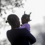 
              A woman holds a girl at a migrant camp in Ciudad Acuña, Mexico, Thursday, Sept. 23, 2021. Mexico security forces deployed to block immigrants, most of them from Haiti, who had camped in the park beside the Rio Grande so they can't cross the U.S.-Mexico border. (AP Photo/Felix Marquez)
            