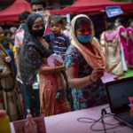 
              People wait to register themselves to receive vaccine for COVID-19 during an inoculation drive in New Delhi, India, Wednesday, Sept. 29, 2021. India, the world’s largest vaccine producer, will resume exports and donations of surplus coronavirus vaccines in October after halting them during a devastating surge in domestic infections in April. (AP Photo/Altaf Qadri)
            