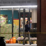 
              An FBI agent walks past an entrance to a Kroger grocery store as an investigation goes into the night following a shooting earlier in the day on Thursday, Sept. 23, 2021, in Collierville, Tenn. Police say a gunman attacked people in the store and killed at least one person and wounded 12 others before the suspect was found dead. (AP Photo/Mark Humphrey)
            